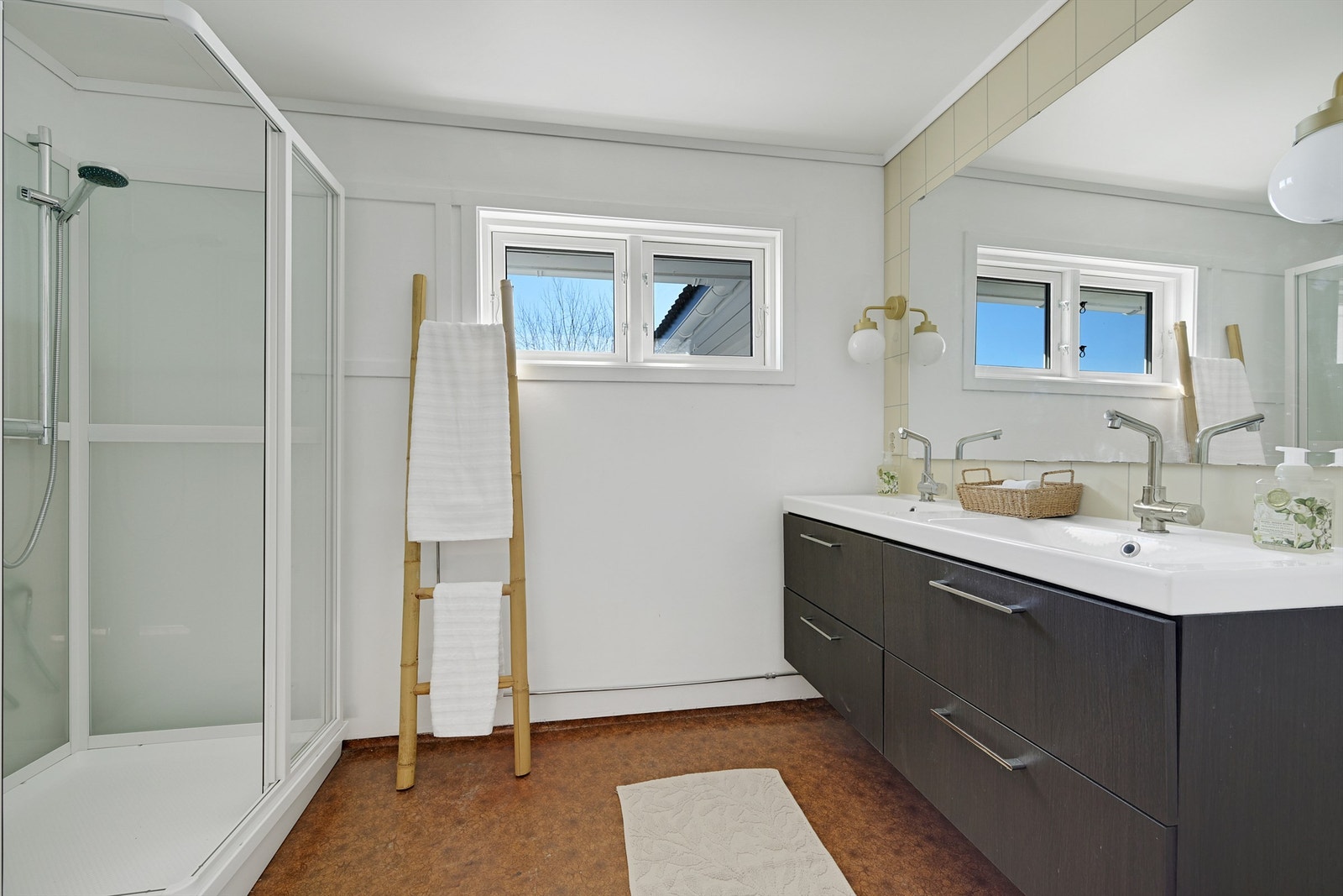 Badet har belegg på gulvet og fliser/malte vegger. På badet er det dusjkabinett, toalett og servant med underskap. Galleribilde