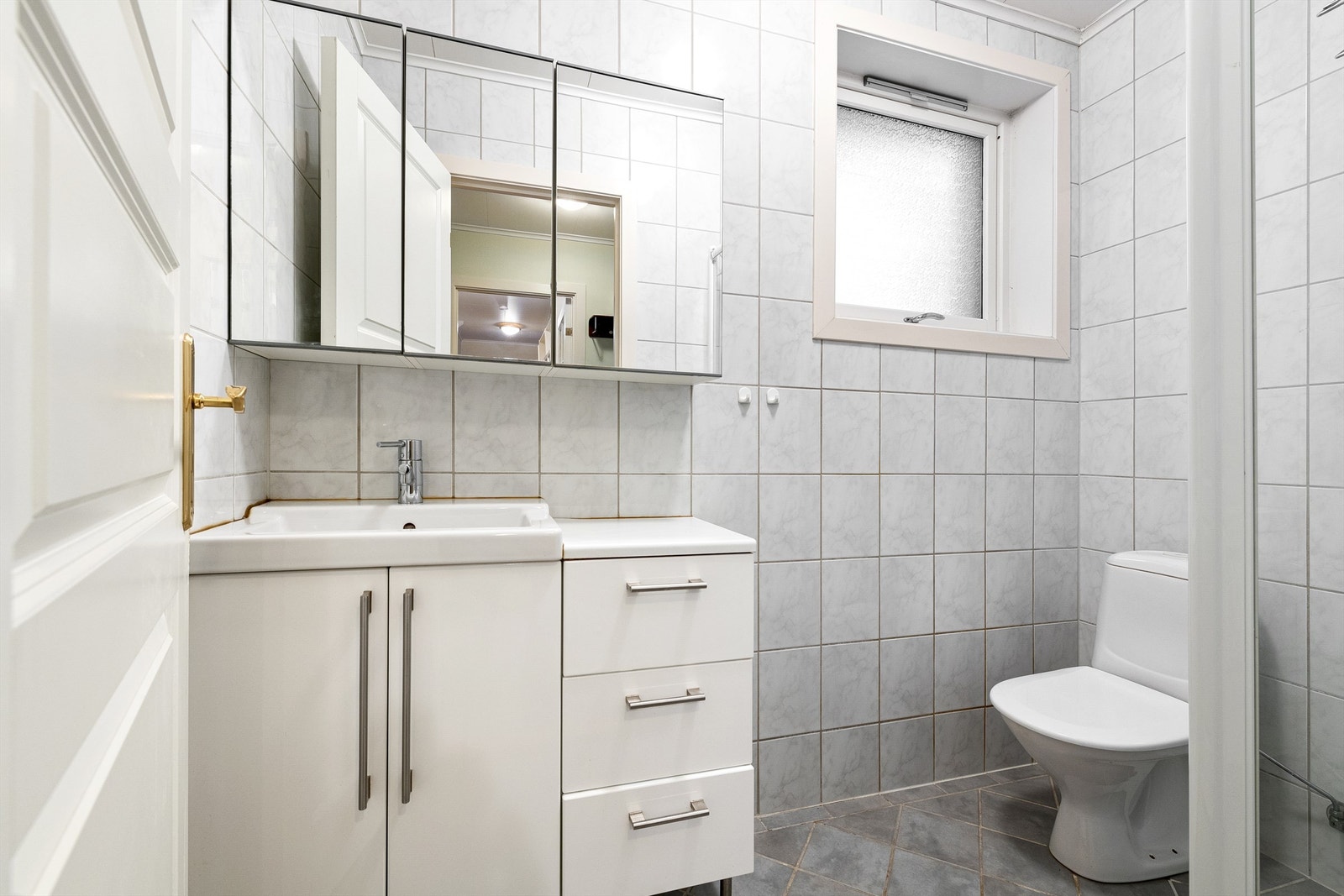 Badet ble oppgradert rundt 2003 og har flislagt gulv med varmekabler, flislagte vegger og malt tak. Hvit baderomsinnredninbg med skuffer og skap og ovenpåliggende servant med ett-greps armatur. Galleribilde