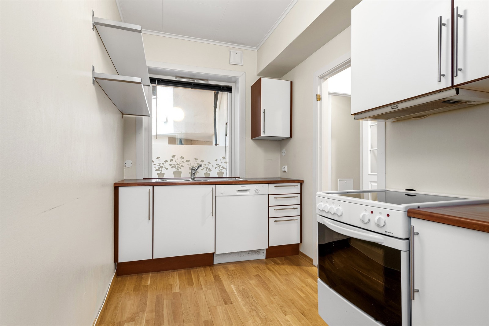 Kjøkkenet har innredning med glatte fronter med kirsebærfargede kanter fra ca 2003. Benkeplaten er av laminat Galleribilde