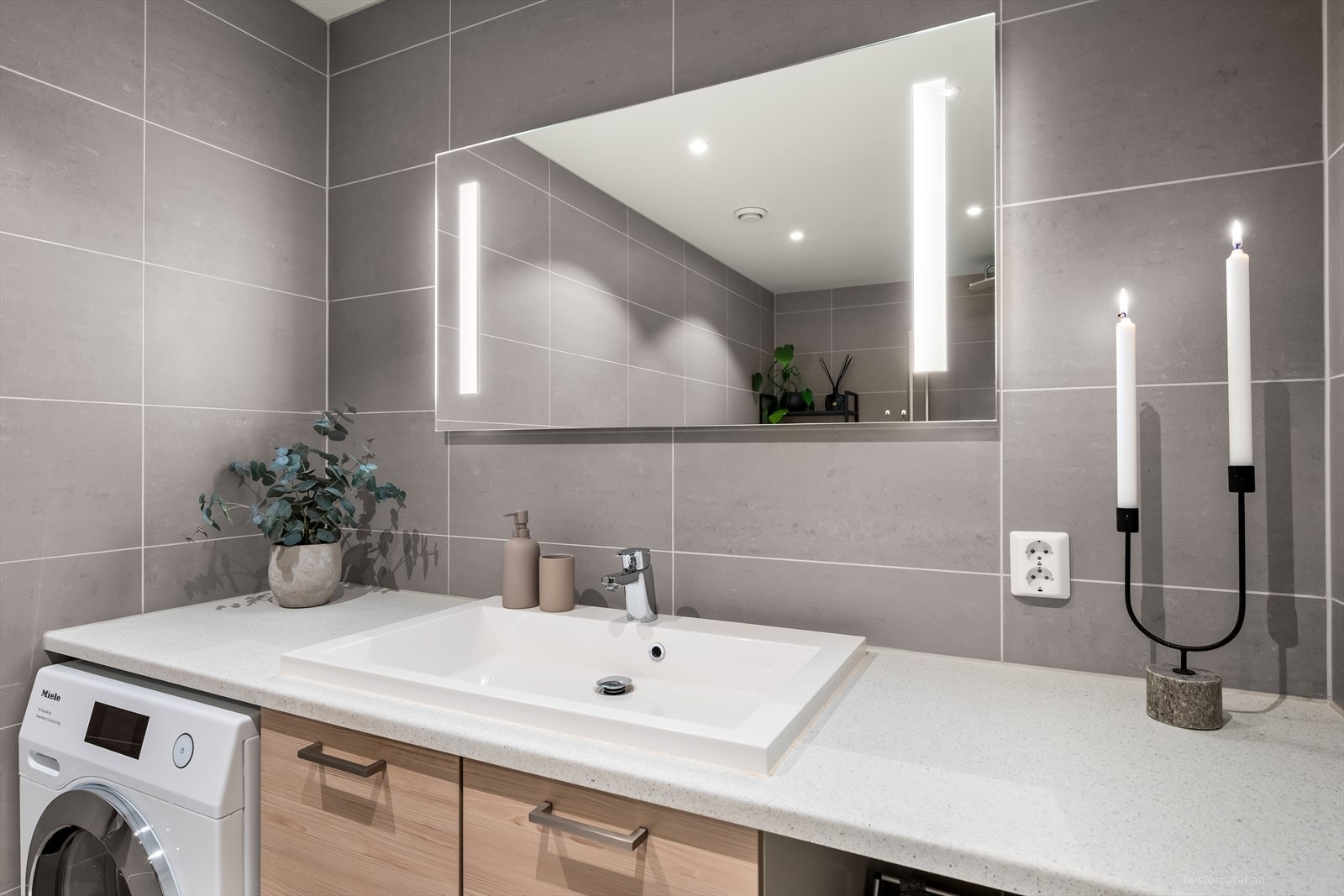 Badet i underetsje har nedfelt servant, speil med lys. Skuffer under vask. Fliser på gulv og vegger, pen benkeplate. Opplegg for vaskemaskin. Galleribilde