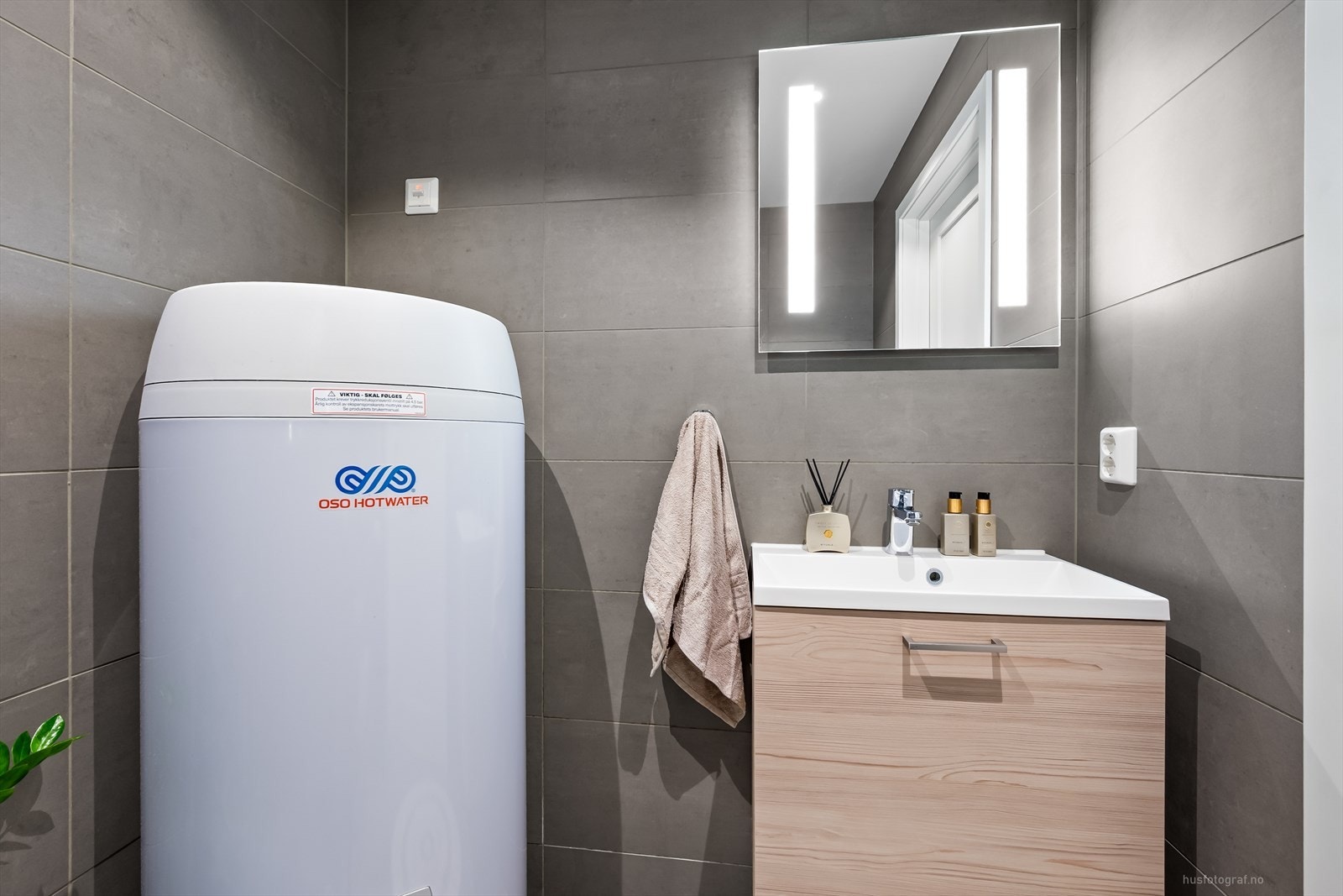 Bad 1.etasje har servant og skuffeseksjon. Speil med lys. Galleribilde