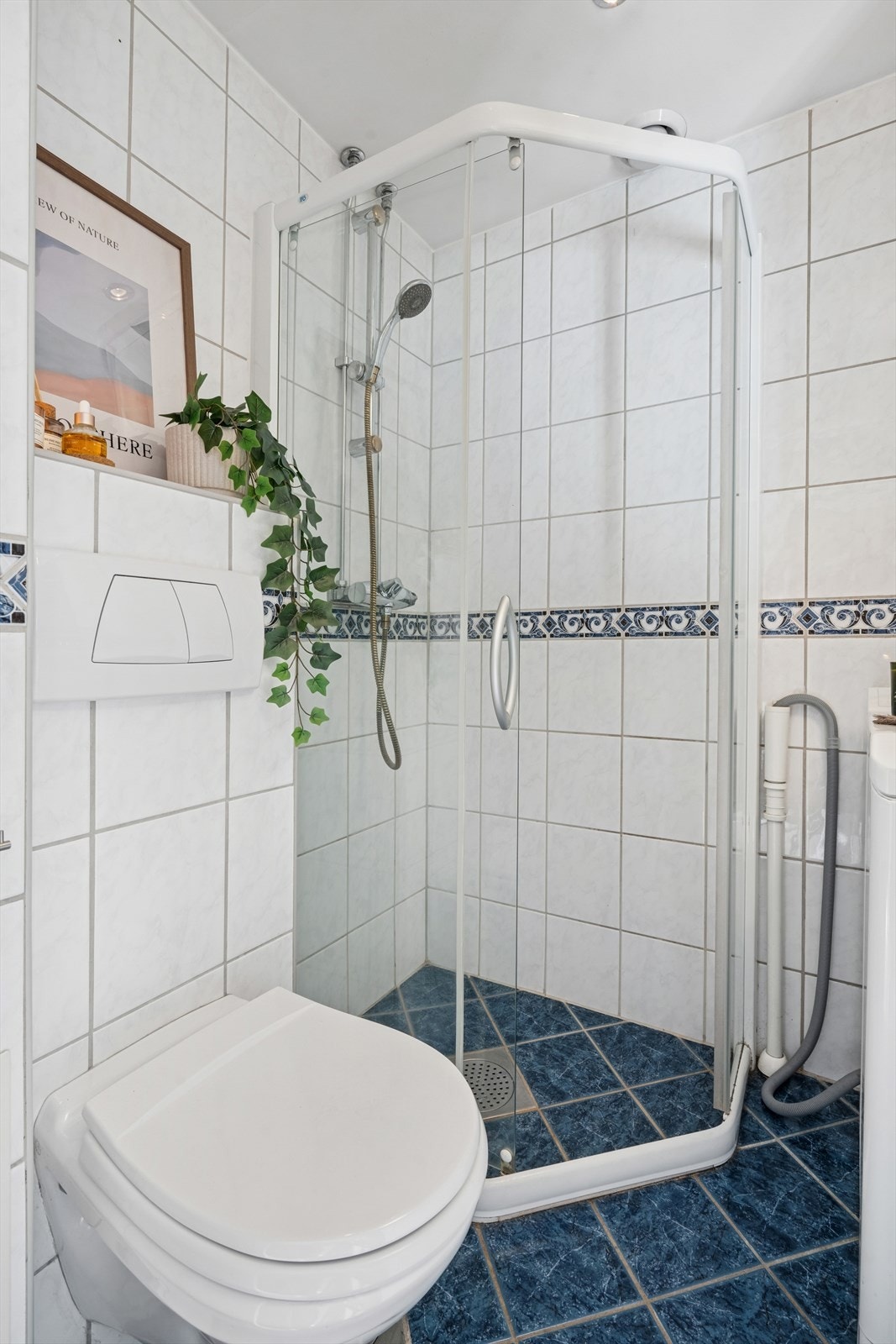 Rommet er innredet med dusjhjørne, servantseksjon, innmurt speil med belysning og vegghengt toalett. Det er opplegg for både vaskemaskin og tørketrommel, noe som gjør badet svært praktisk i bruk Galleribilde