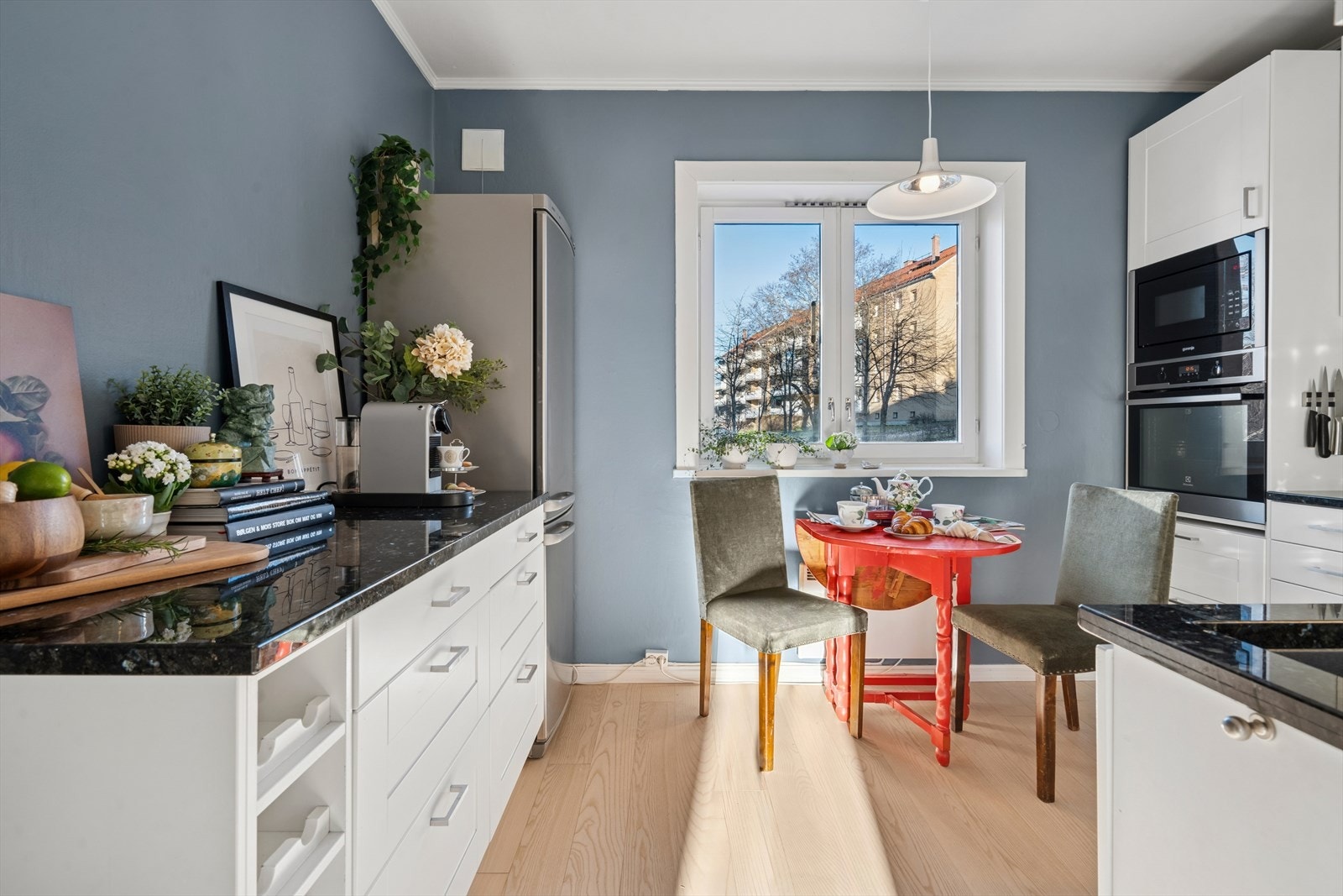 Flott og funksjonelt kjøkken med moderne, slette hvite fronter, eksklusive granitt benkeplate (mørk labrador) og nedfelt vask Galleribilde