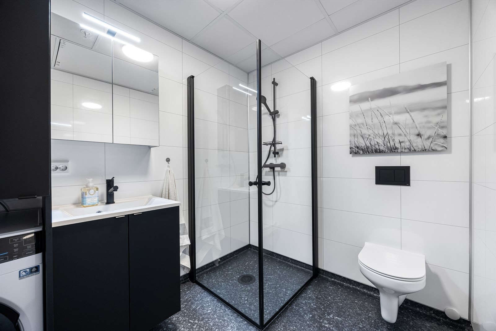 Flott bad med vegghengt wc, dusjhjørne, servant og speilskap. Gulvvarme. Galleribilde