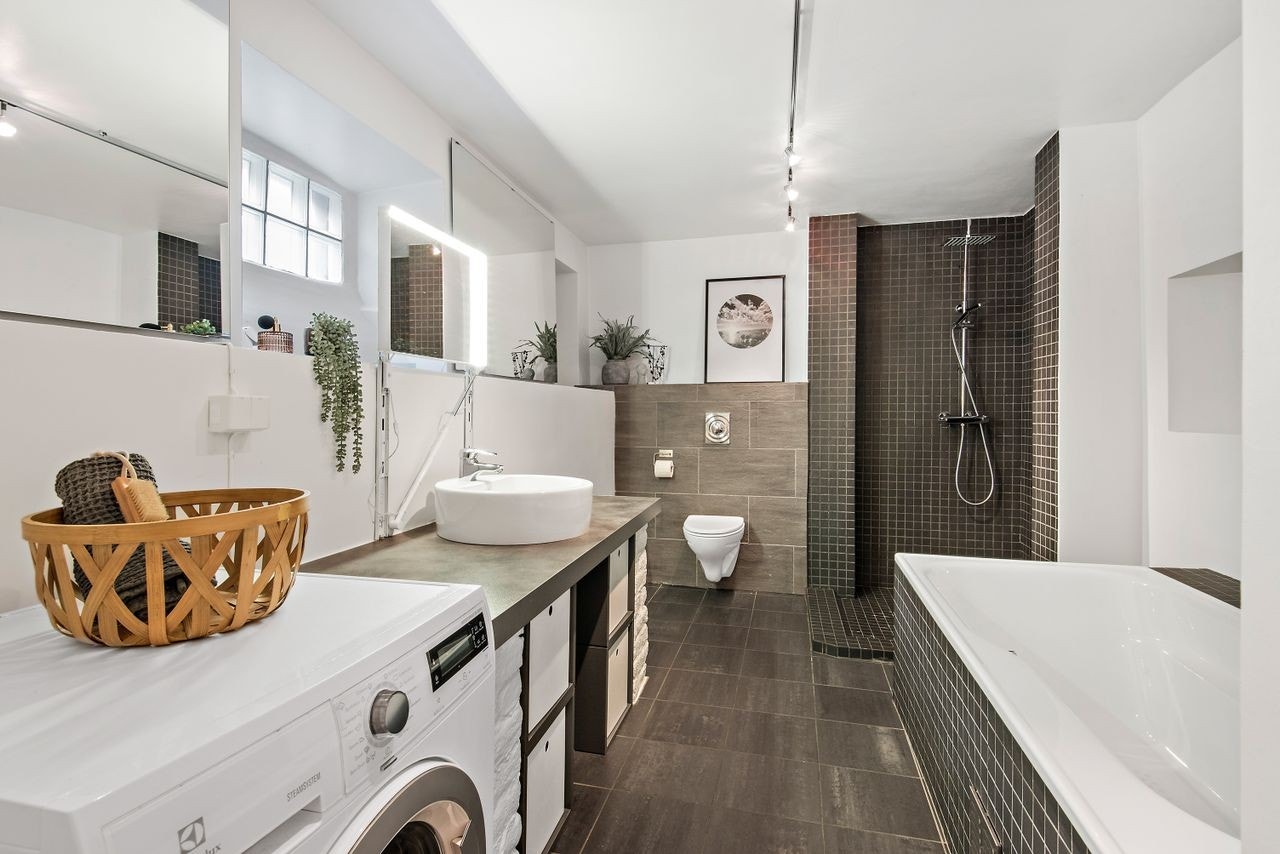 Pent flislagt bad med både disjhjørne og badekar Galleribilde