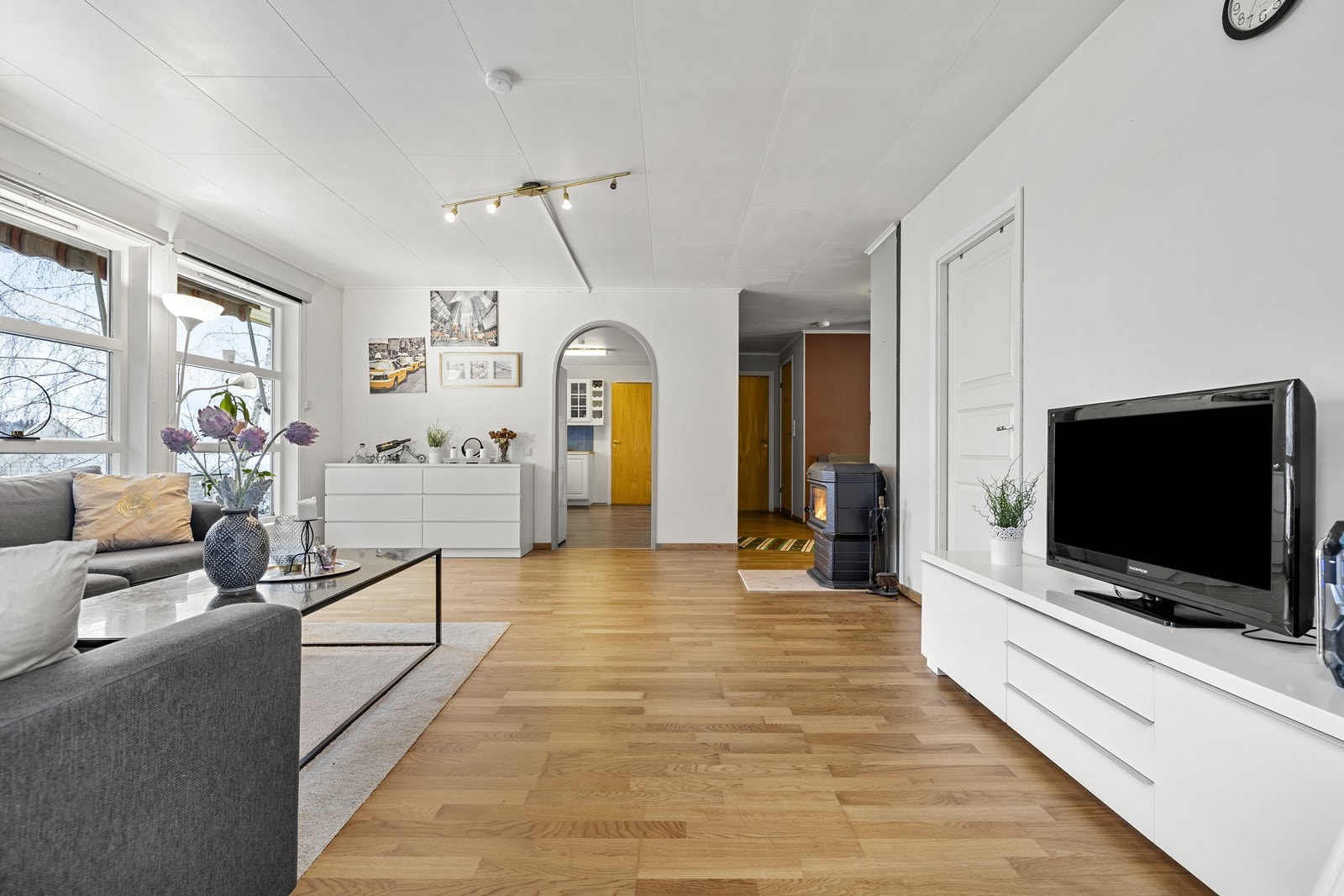 Lys og romslig stue med parkettgulv og store vindusflater som gir rikelig med naturlig lys. Galleribilde