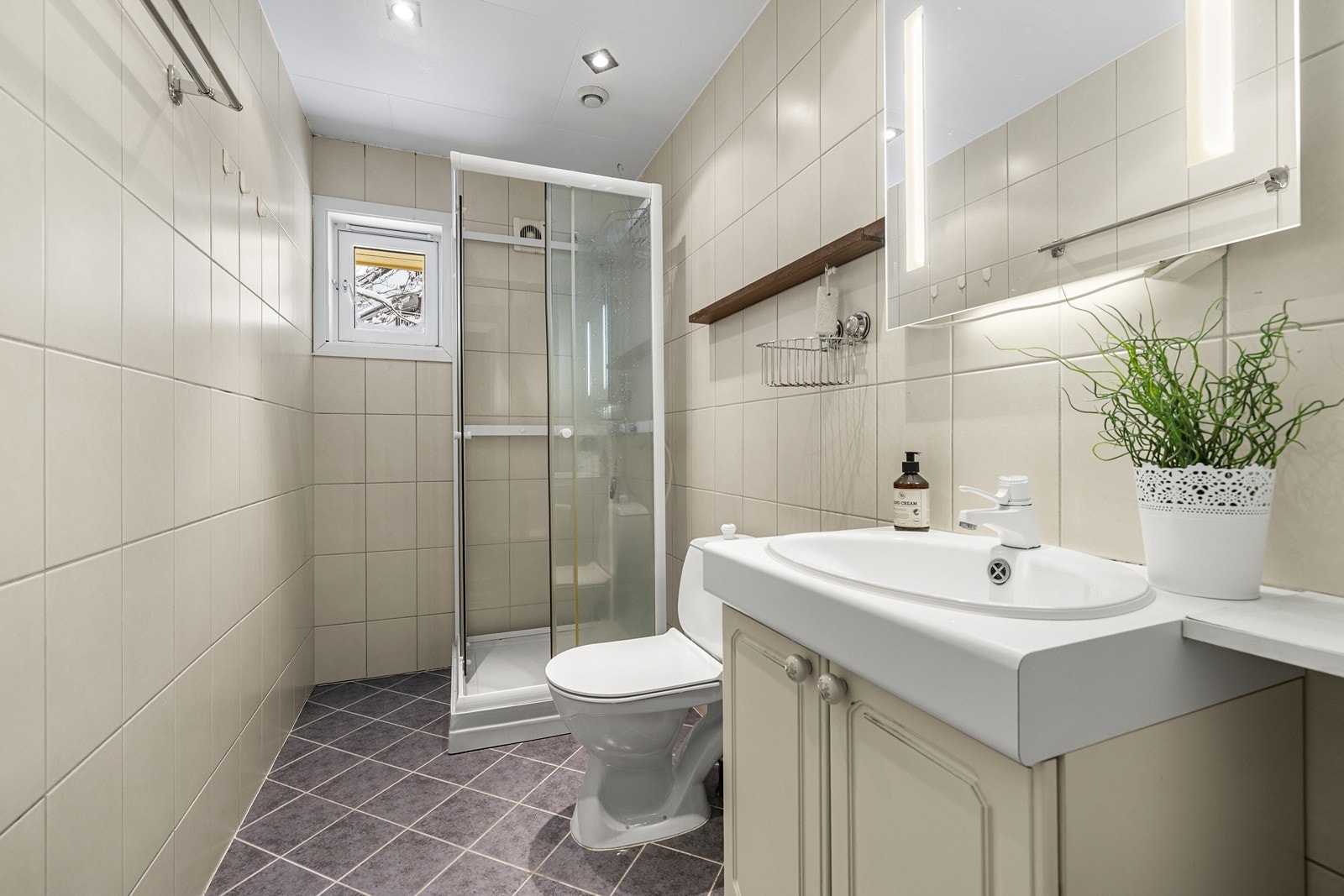 Bad med flislagt gulv og vegger, dusjløsning og varmekabler i gulv. Galleribilde