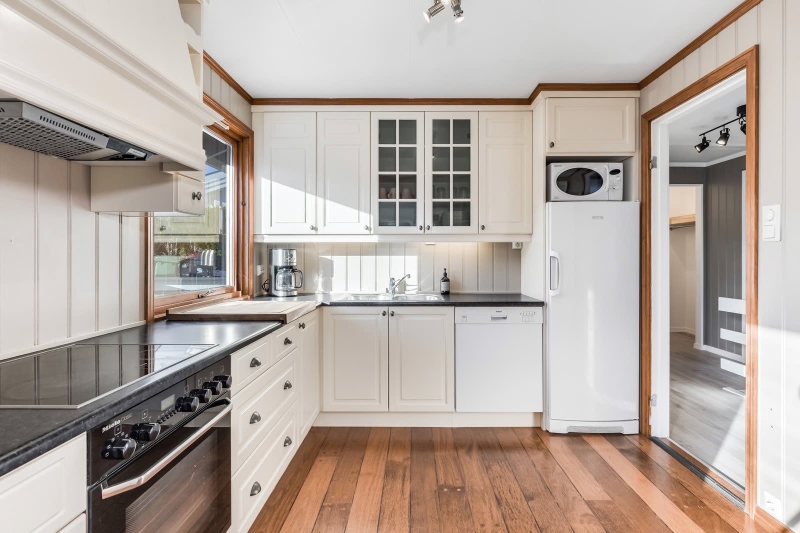 Klassisk og pen innredning med medfølgende hvitevarer. Laminat benkeplate, panelvegger, skipsparkett. Galleribilde