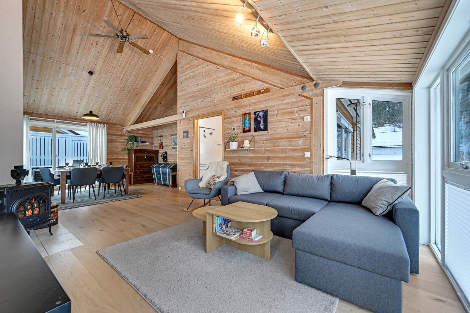 Stue med stor takhøyde og peis ovn. Galleribilde