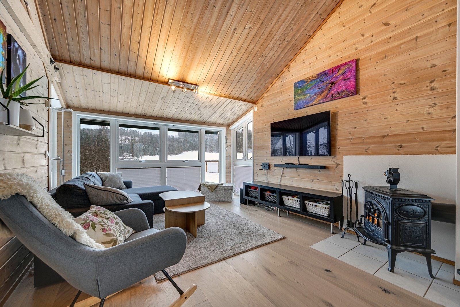 Stue med stor takhøyde og peis ovn. Galleribilde