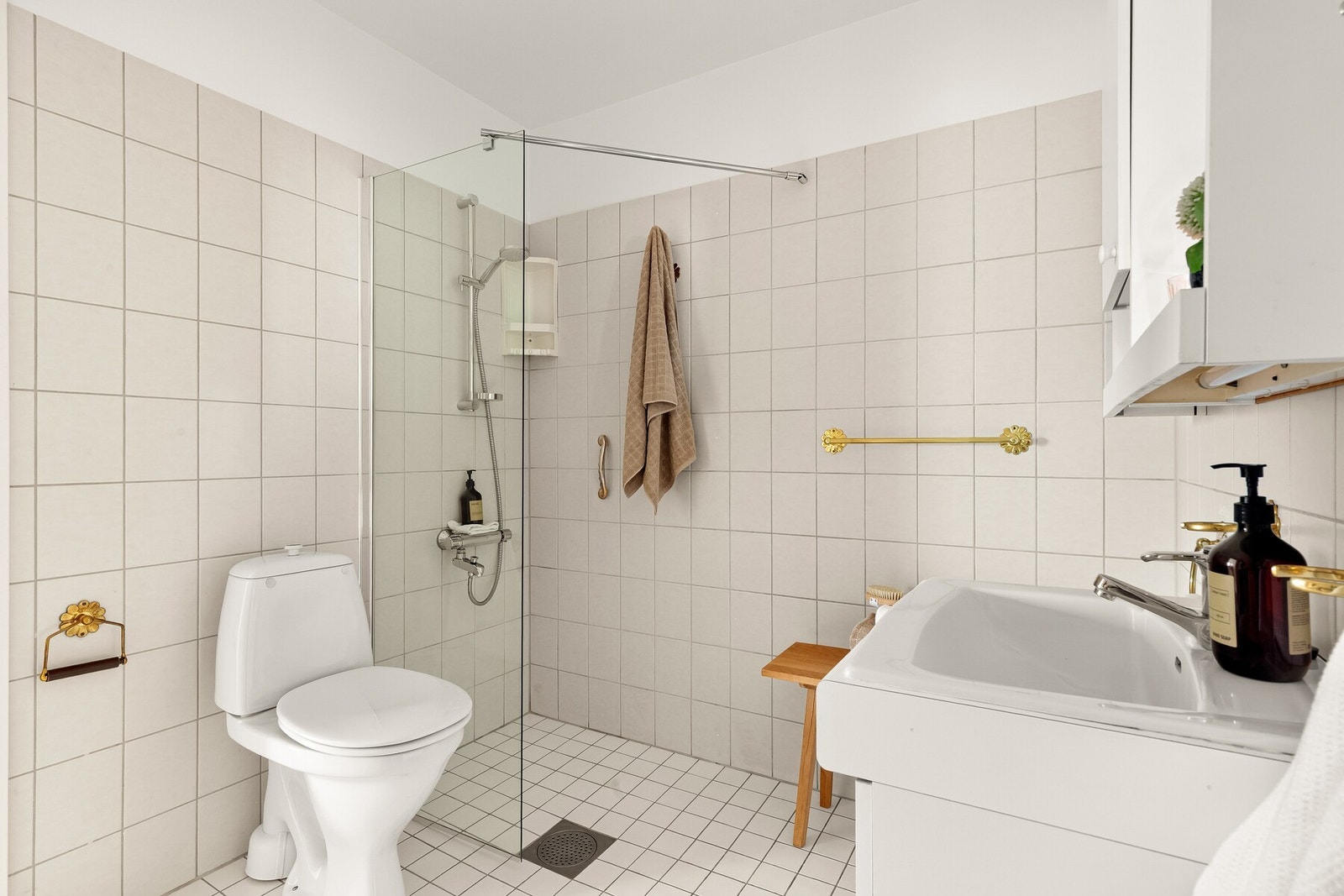 Varmekabler i gulvet gir ekstra komfort, og rommet er innredet med servant med underskap, toalett og dusjhjørne med vegger. Galleribilde