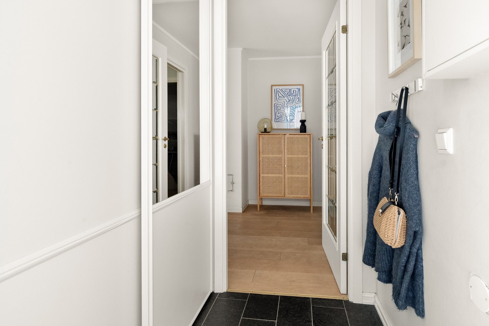 Boligen ønsker deg velkommen med en praktisk entré med skiferfliser med gulvvarme, moderne overflater og romslig skyvedørsgarderobe fra 2015. Galleribilde