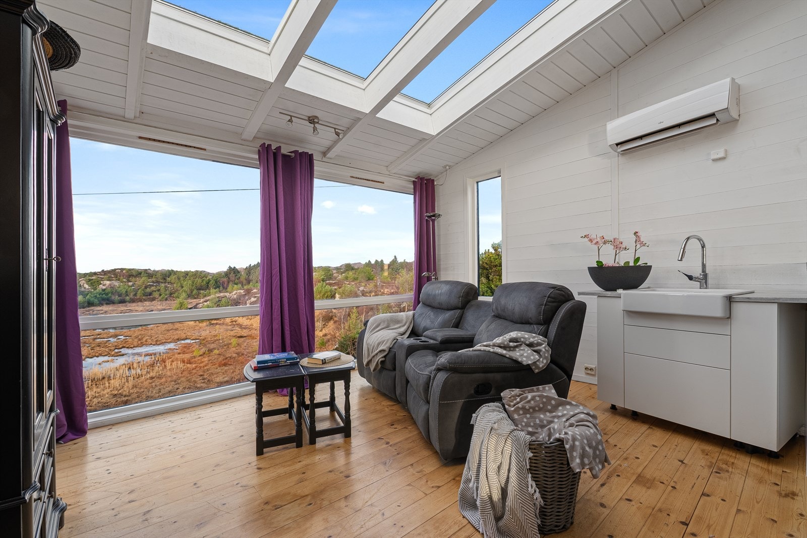 Del av stue som har store vindusflater som gir godt lys. Galleribilde