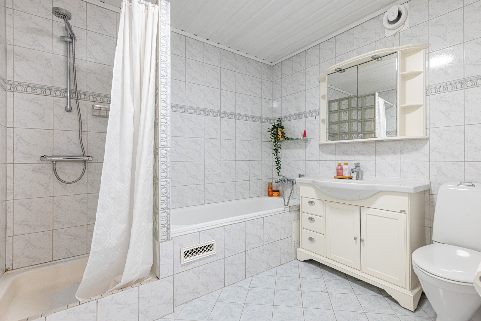 Flislagt baderom nede med både dusj og badekar. Galleribilde