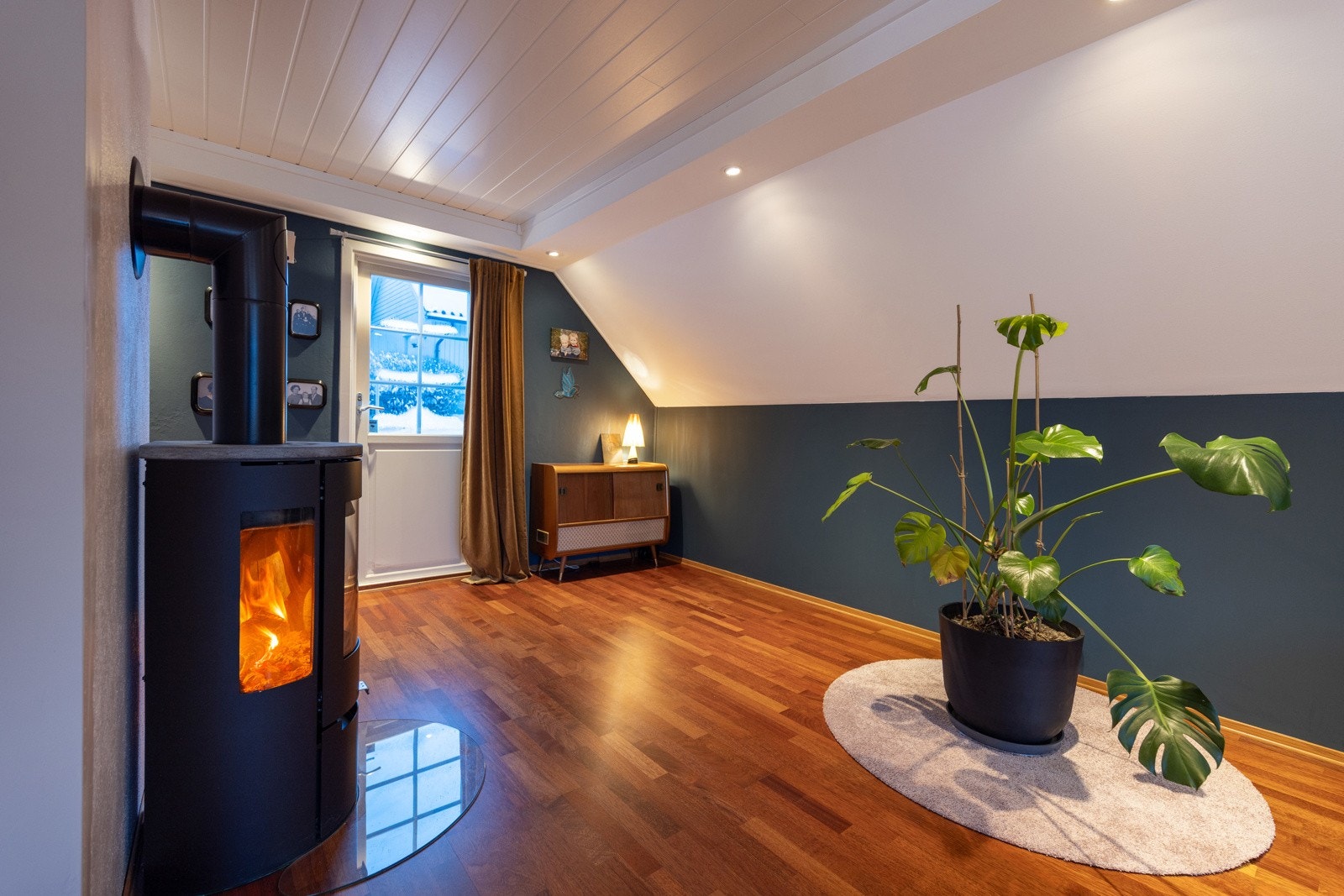 Overflater med parkettgulv og lysmalte vegger med en kontrastvegg i blått. Galleribilde