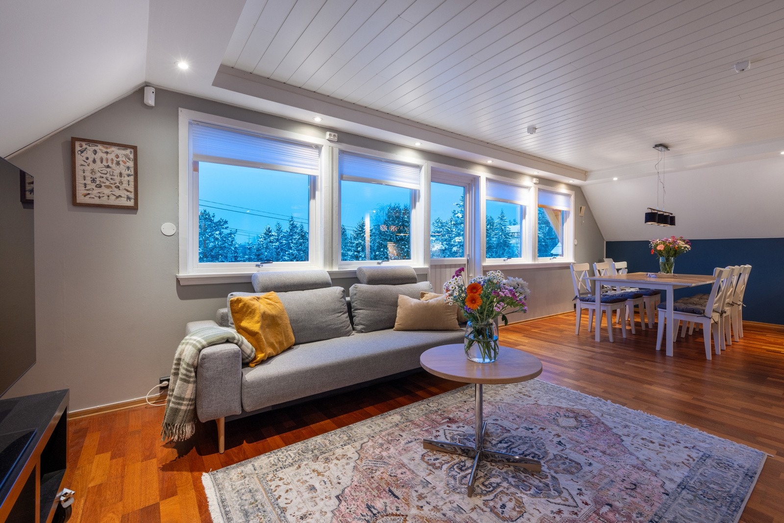 Stuen har en fin utforming med plass til ulike soner for sofagruppe, spisebord ved kjøkkenet, og hyggelig lesekrok ved peisen. Galleribilde