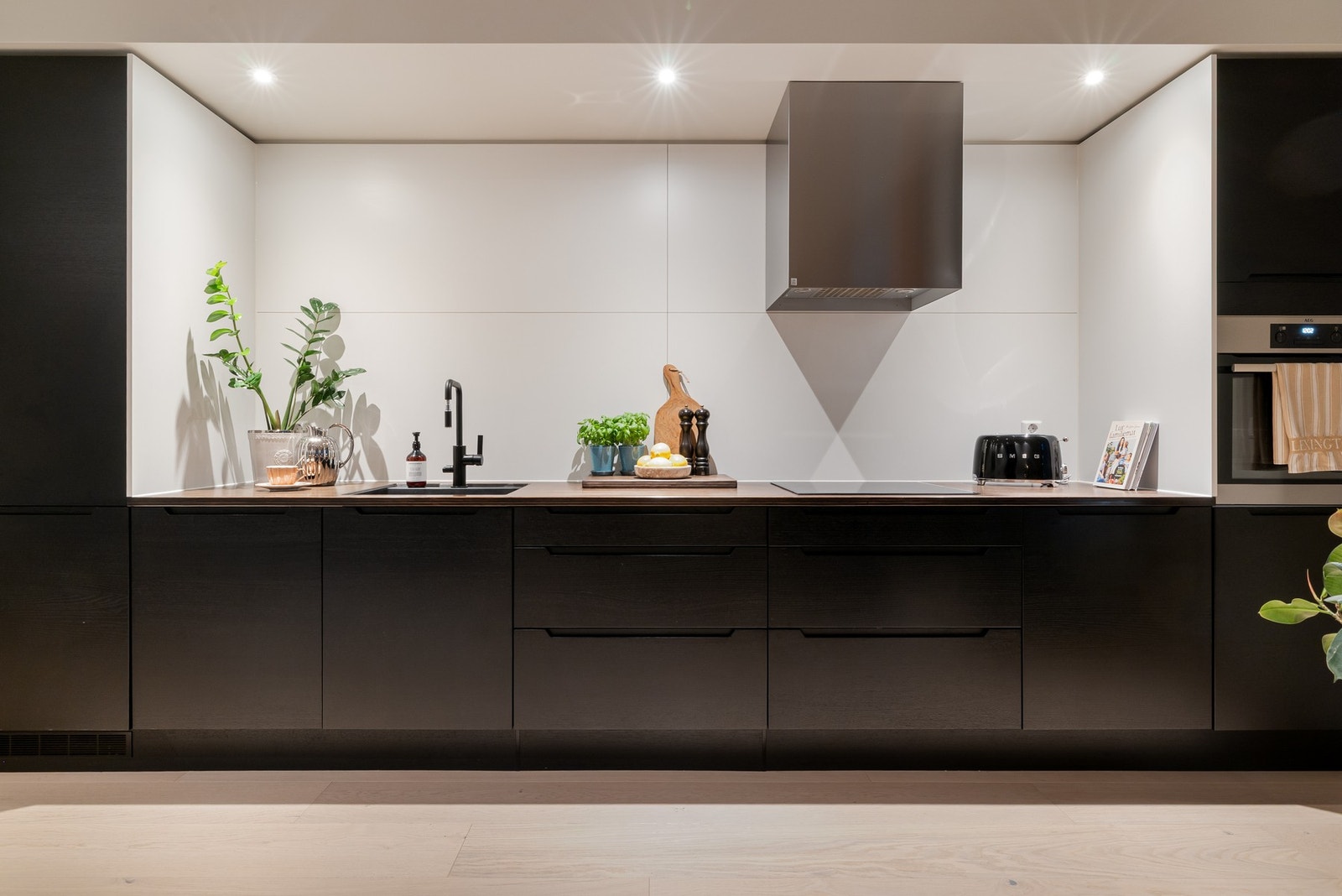 Moderne kjøkken med mørke fronter og integrerte hvitevarer Galleribilde