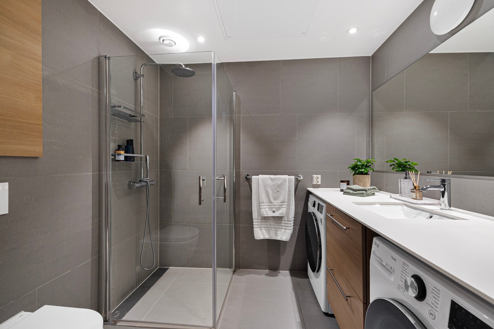 Fin fargepalett og gjennomtenkte løsninger. Opplegg for både vaskemaskin og tørketrommel under benk Galleribilde