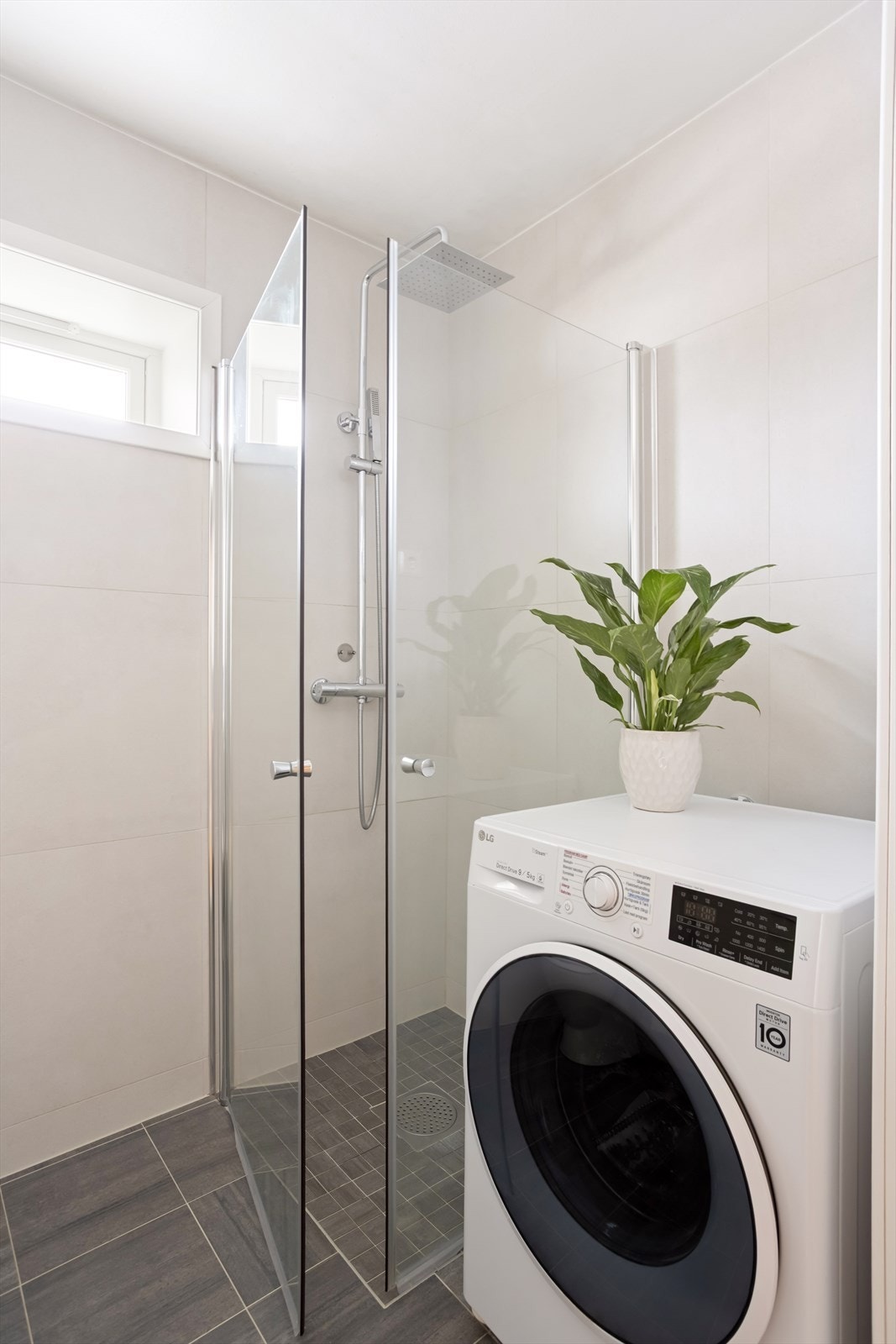 Badet består av heldekkende servant på underskap med folierte fronter, speilskap, lysarmatur og gulvmontert klosett, dusjhjørne med svingbare rette dusjdører, termostatstyrt dusjbatteri og dusjutstyr, samt opplegg for vaskemaskin. Galleribilde