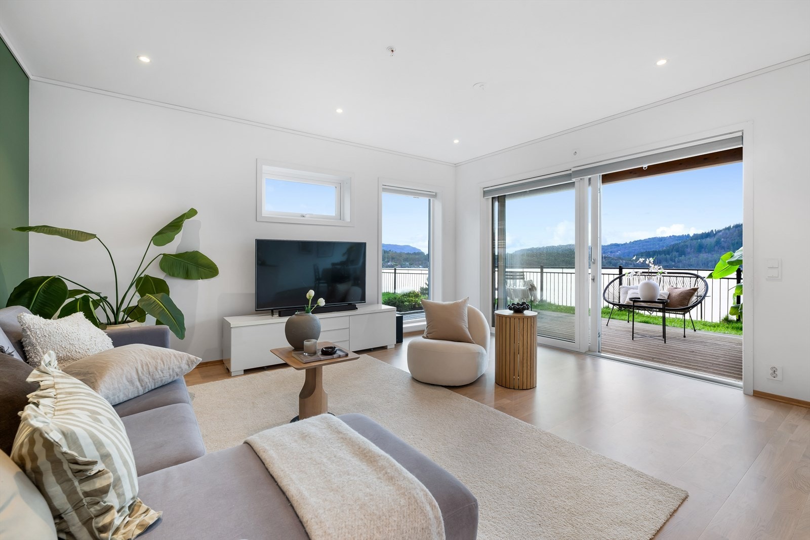Lys og innbydende stue med store vinduer som gir fantastisk utsikt og direkte tilgang til romslig balkong. Galleribilde