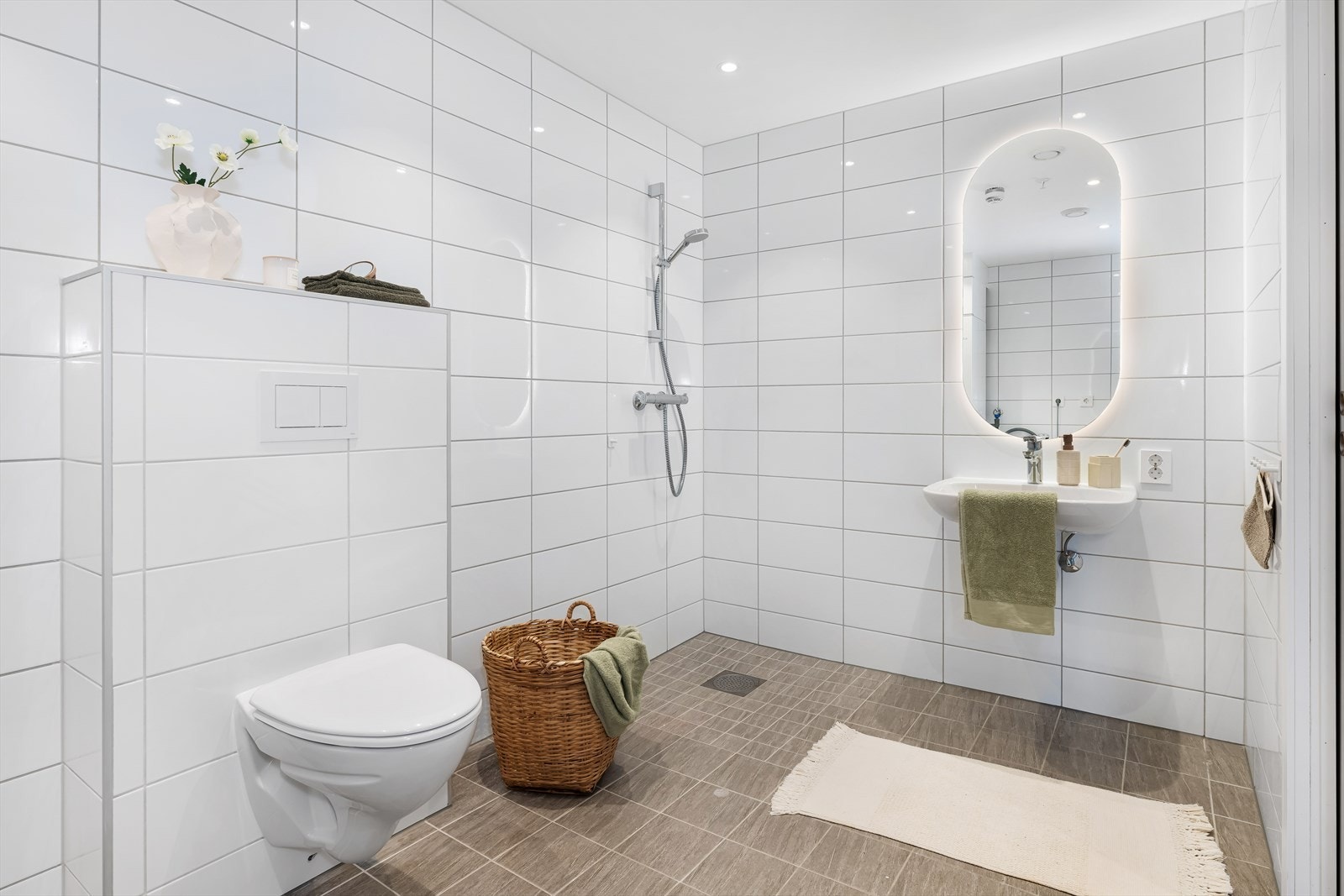 Lyst og moderne bad med flislagte vegger og gulv, malt tak og elektriske varmekabler. Galleribilde