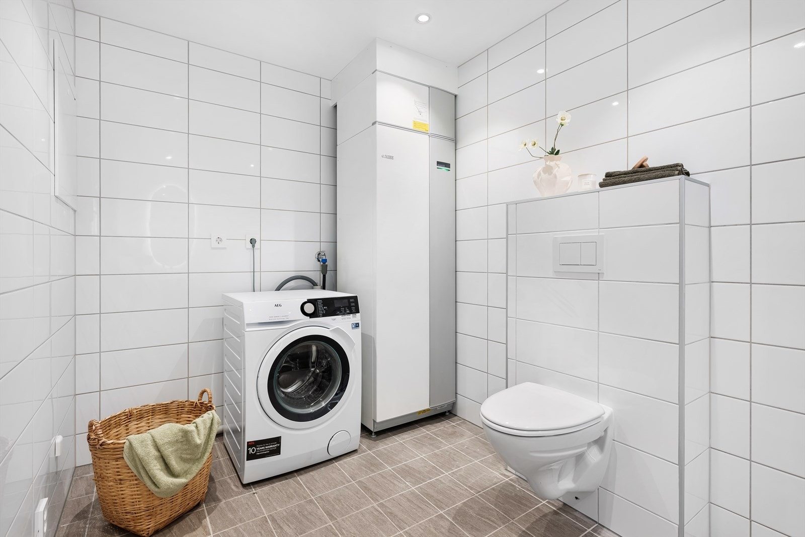 Innredningen består av servant, toalett, dusjgarnityr og opplegg for vaskemaskin. Galleribilde