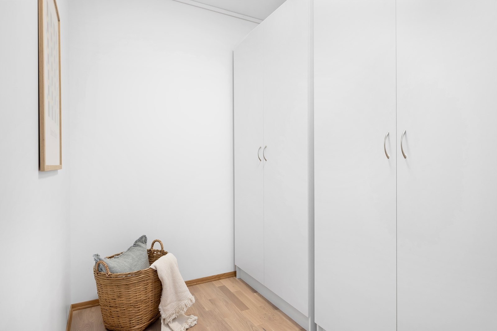 Lys og romslig garderobe med stilrene, hvite skap. Perfekt for organisering og oppbevaring i ditt nye hjem. Galleribilde