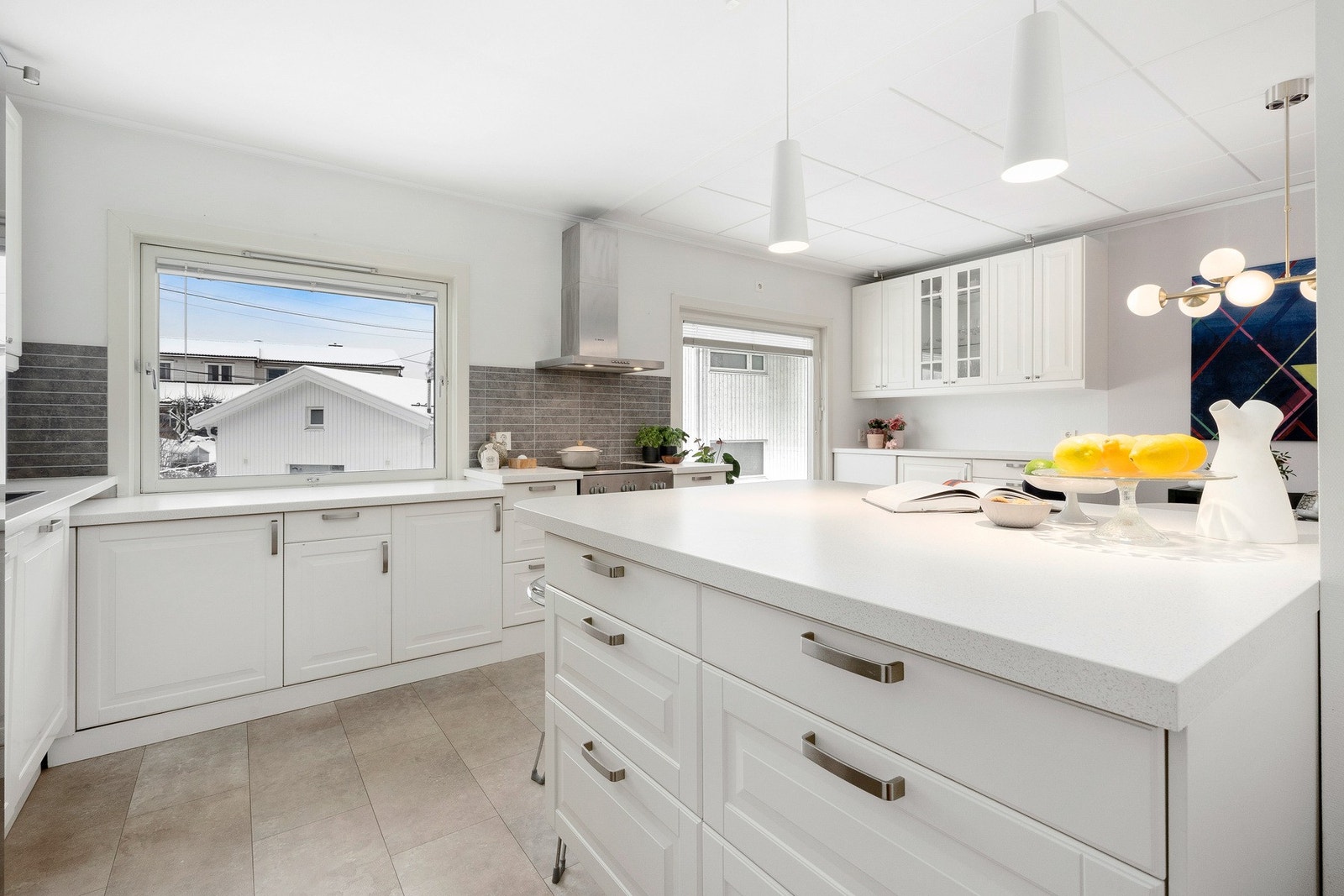 Lyst og hyggelig kjøkken med smart kjøkkenøy med mye lagringsplass, samt barløsning. Galleribilde