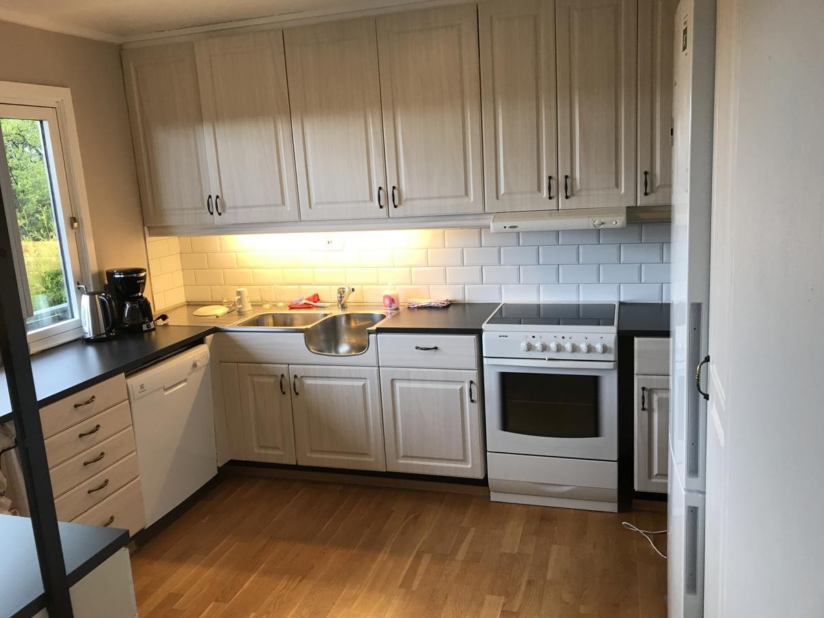 ny kjøkken benk og oppvaskmaskin og stort kjøleskap med frys. Galleribilde