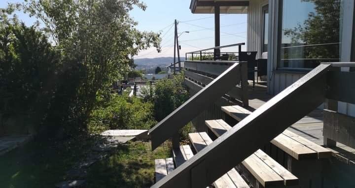 Trapp fra den brede store verandaen ned til hagen og grill plass Galleribilde