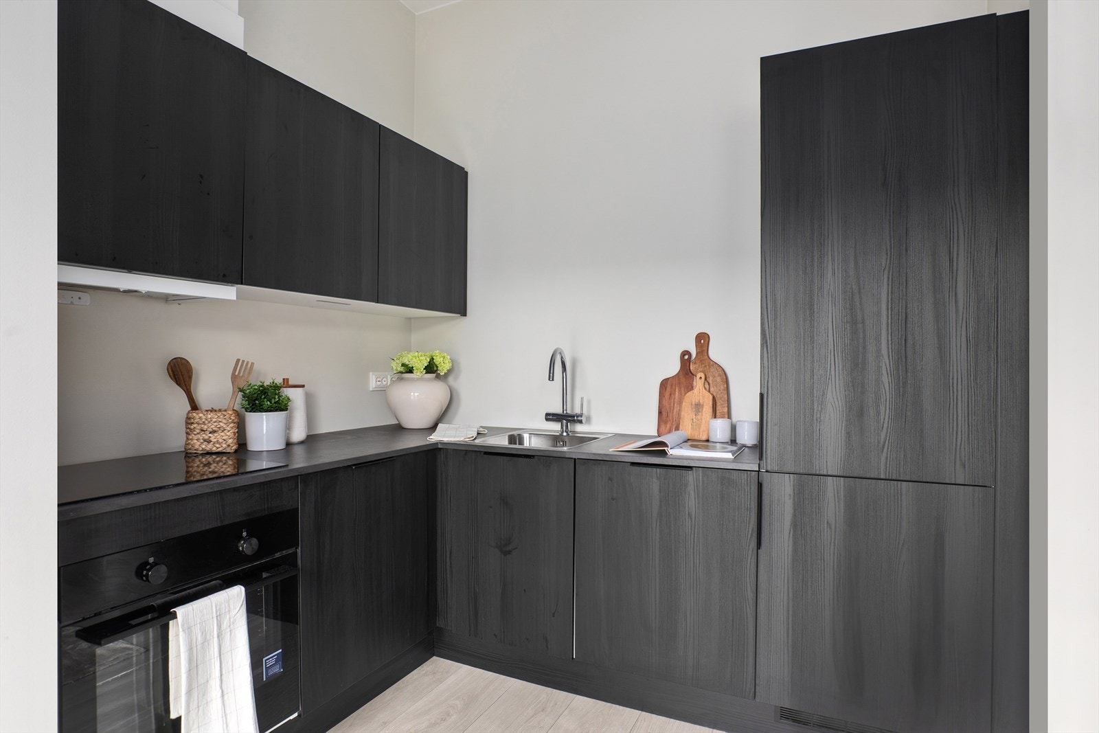 Kjøkkenet har integrerte hvitevarer med oppvaskmaskin, koketopp, stekeovn og kombinert kjøle- og fryseskap Galleribilde