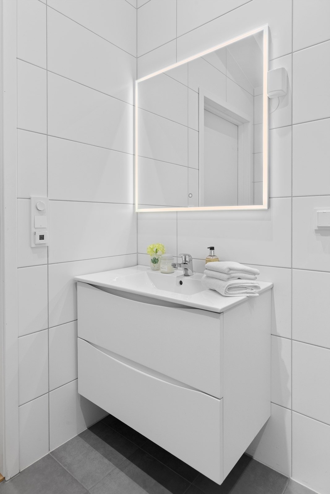 Badet har vegghengt innredning og toalett, dusjhjørne og opplegg for vaskemaskin Galleribilde