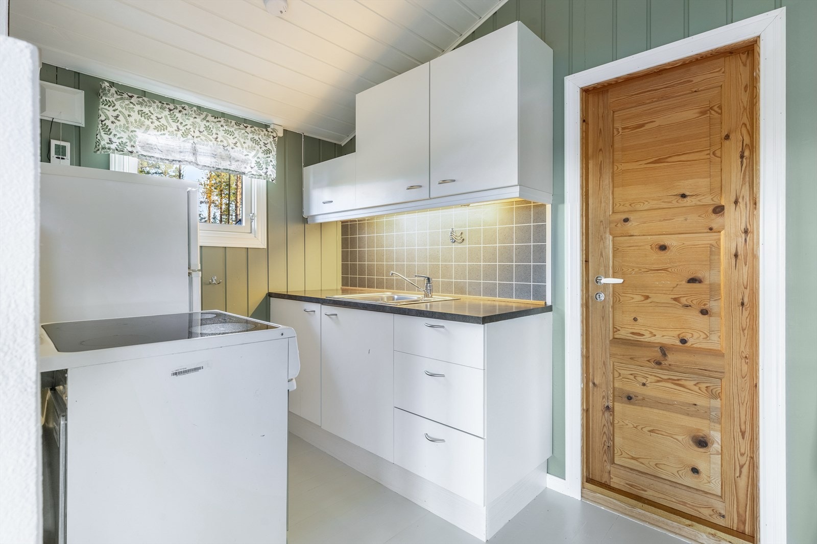 Praktisk kjøkken med kjøleskap og komfyr Galleribilde