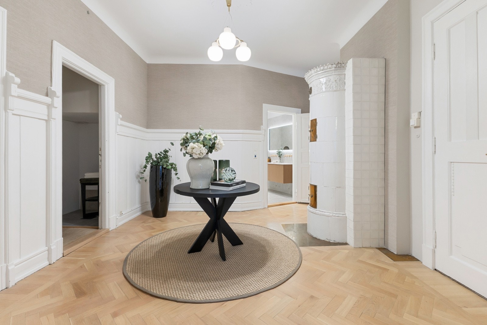 Ditt første møte med hjemmet: romslig hall med gjennomført belysning, lekre overflater og en varm, innbydende stemning. Galleribilde