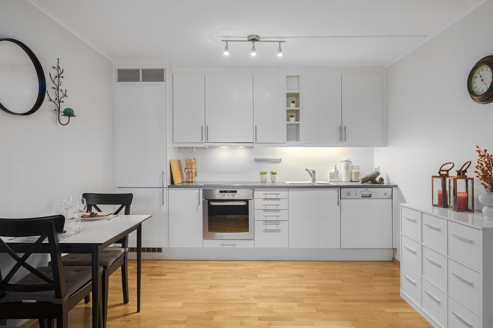 Kjøkkeninnredning med hvite, slette fronter med integrerte hvitevarer. Galleribilde