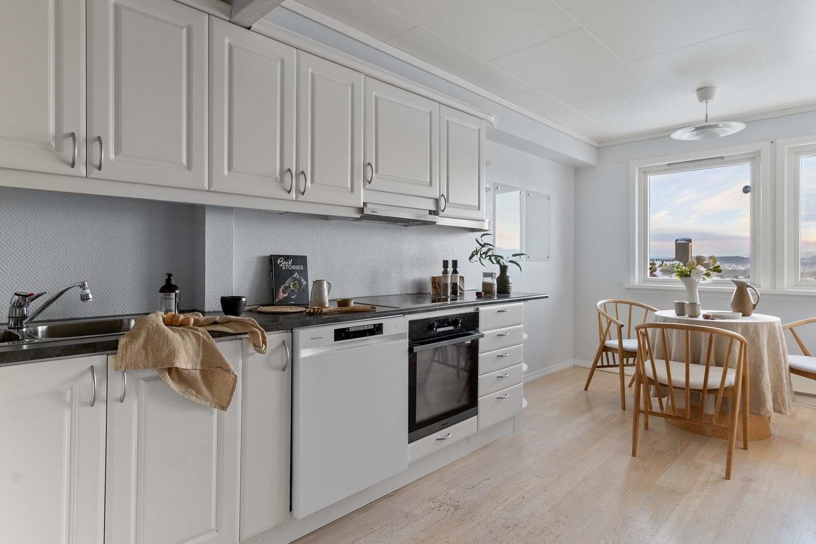 Kjøkkenet er innredet med hvite profilerte fronter og laminat benkeplate. Galleribilde