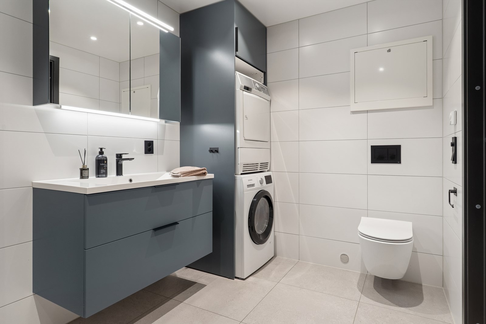 God med skapplass og smart innredning til vaskemaskin og tørketrommel Galleribilde