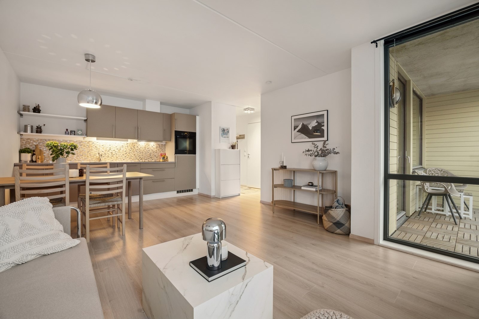 I stuen er det flere store vindusflater som slipper inn rikelig med lys og bidrar til en behagelig atmosfære i leiligheten. Galleribilde