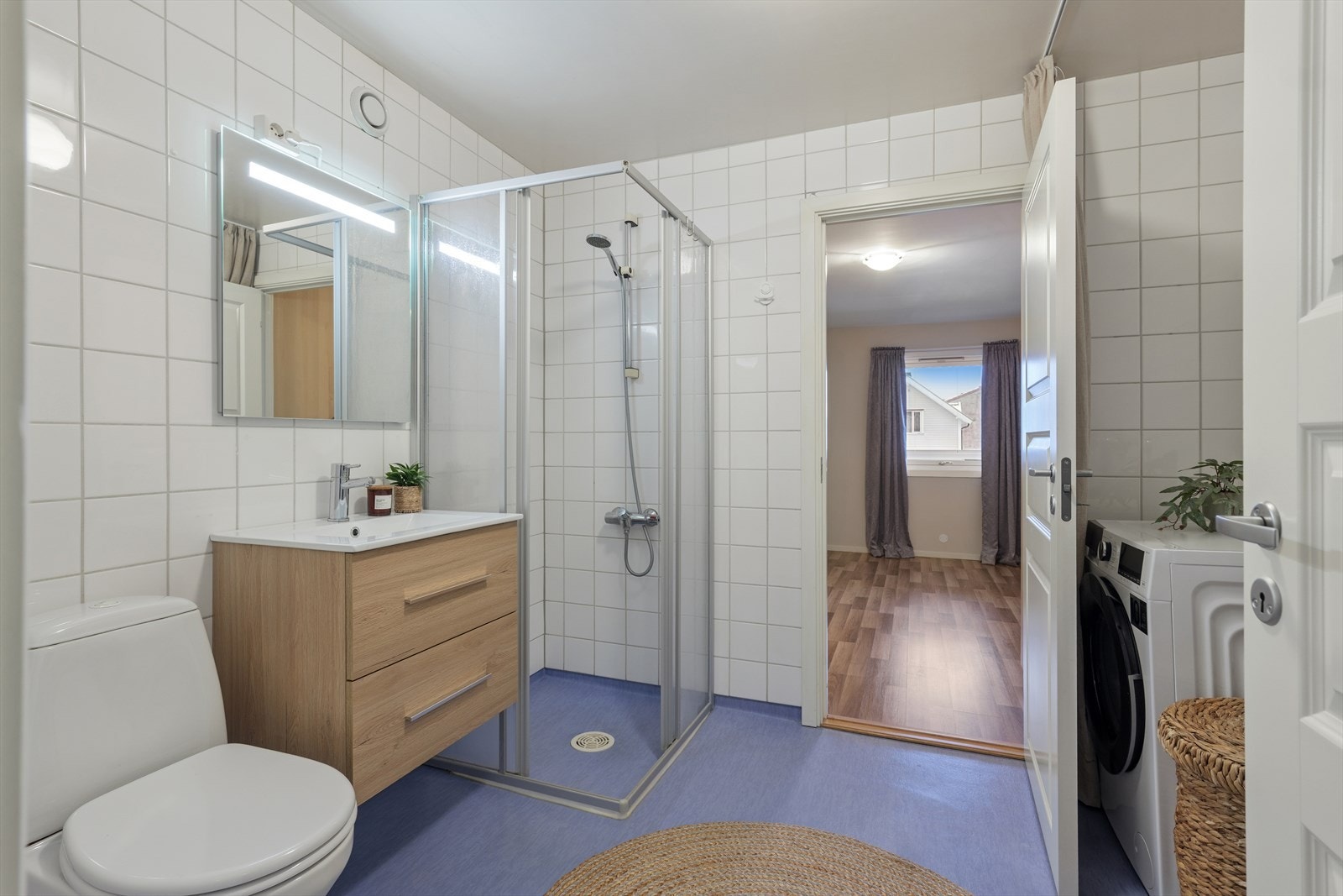 Romslig bad med flislagte vegger og gulv med våtromsbelgge og fliser. Galleribilde