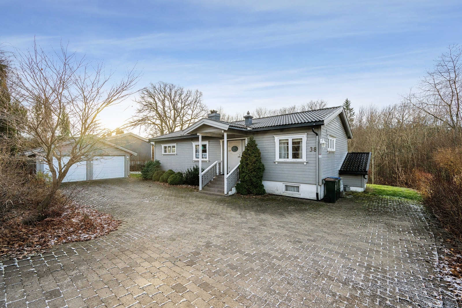 Gårdsplassen er steinbelagt, og byr på god parkeringsplass, i tillegg til den doble garasjen Galleribilde