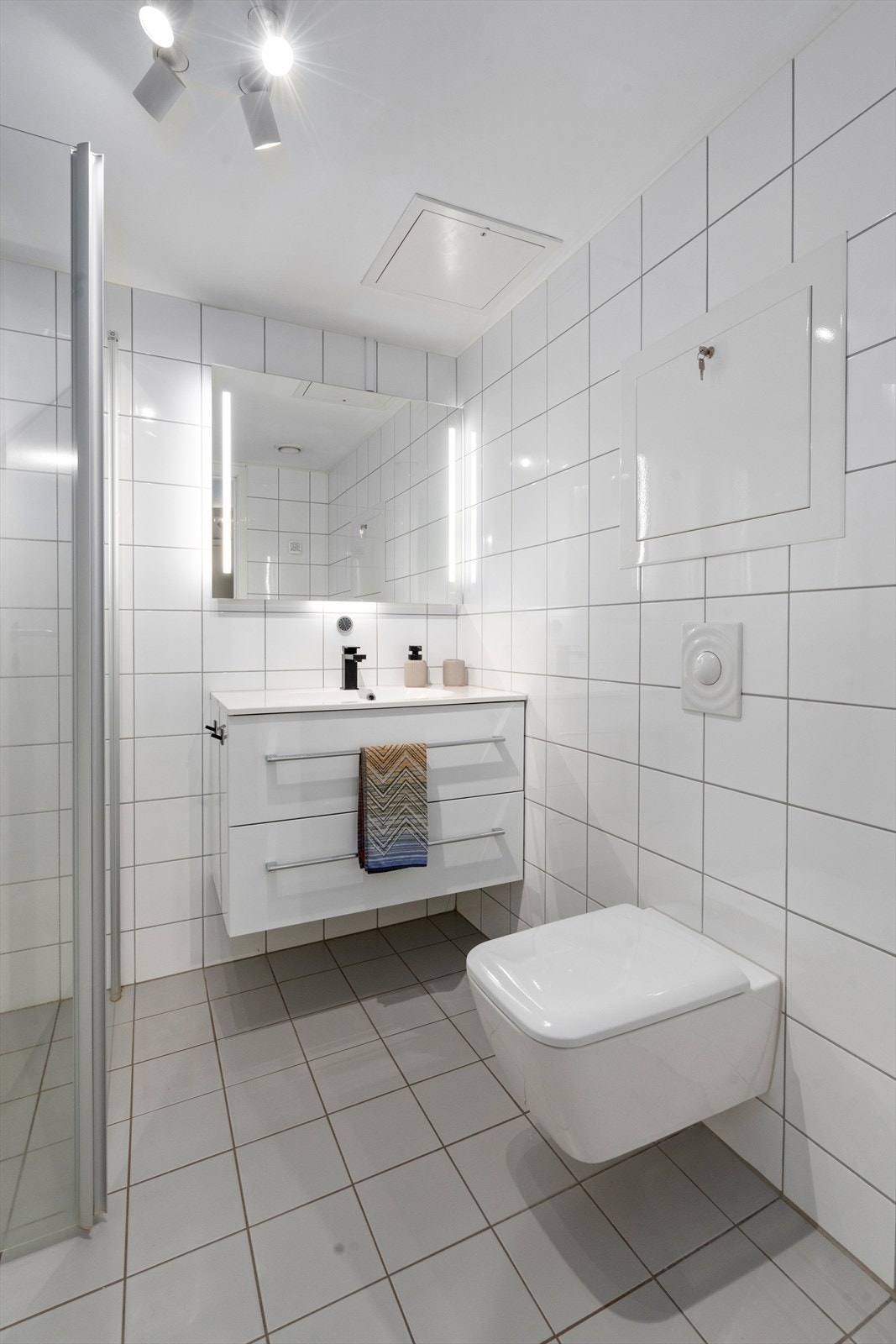 Flislagt bad med god romfølelse, vegghengt wc og innredning med servant. Galleribilde