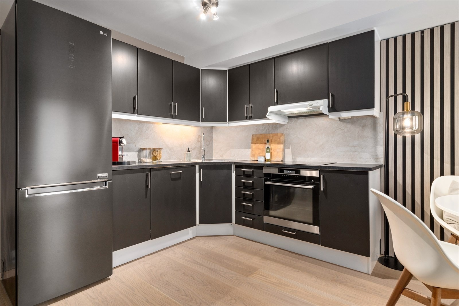 Stilrent kjøkken med mørke fronter og integrerte hvitevarer - gjennomført og funksjonelt. Galleribilde