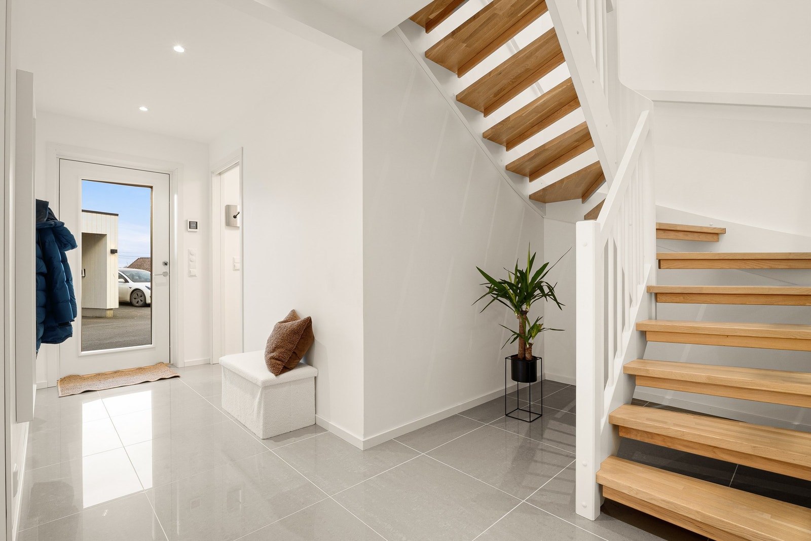 Boligens inngangsparti gir et meget godt førsteinntrykk med store fliser og lyse overflater. Her er også gulvvarme. Galleribilde