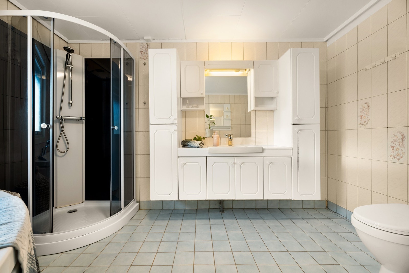 Bad innredet med badekar, dusjkabinett, gulvstående toalett og masse skapplass. Galleribilde