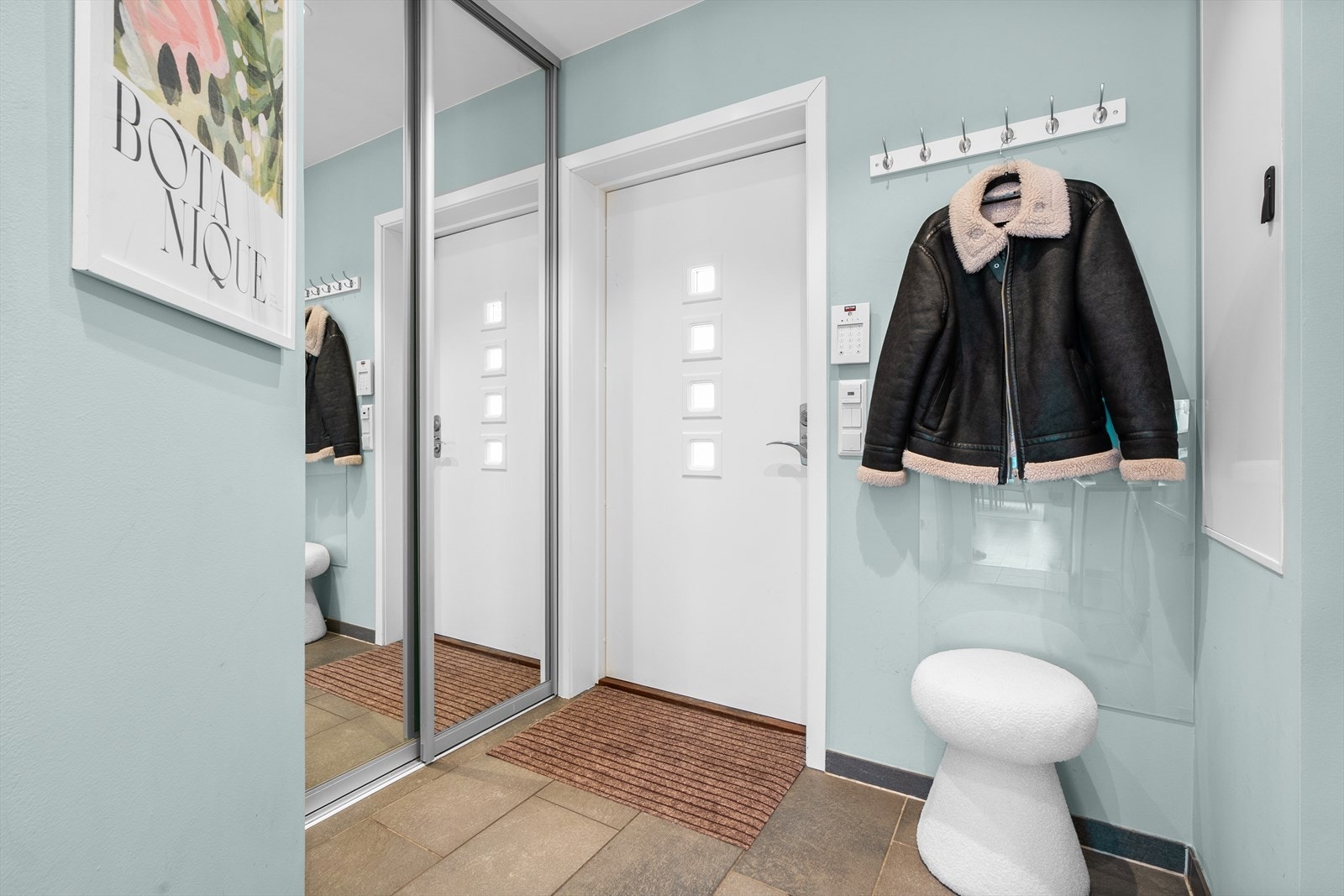 Boligen har en innbydende entré med fliser på gulvet og downlights i himlingen, som gir et lyst og moderne førsteinntrykk. Entréen er romslig og funksjonell, med god plass til oppbevaring av yttertøy i en praktisk og romslig skyvedørsgarderobe. Galleribilde