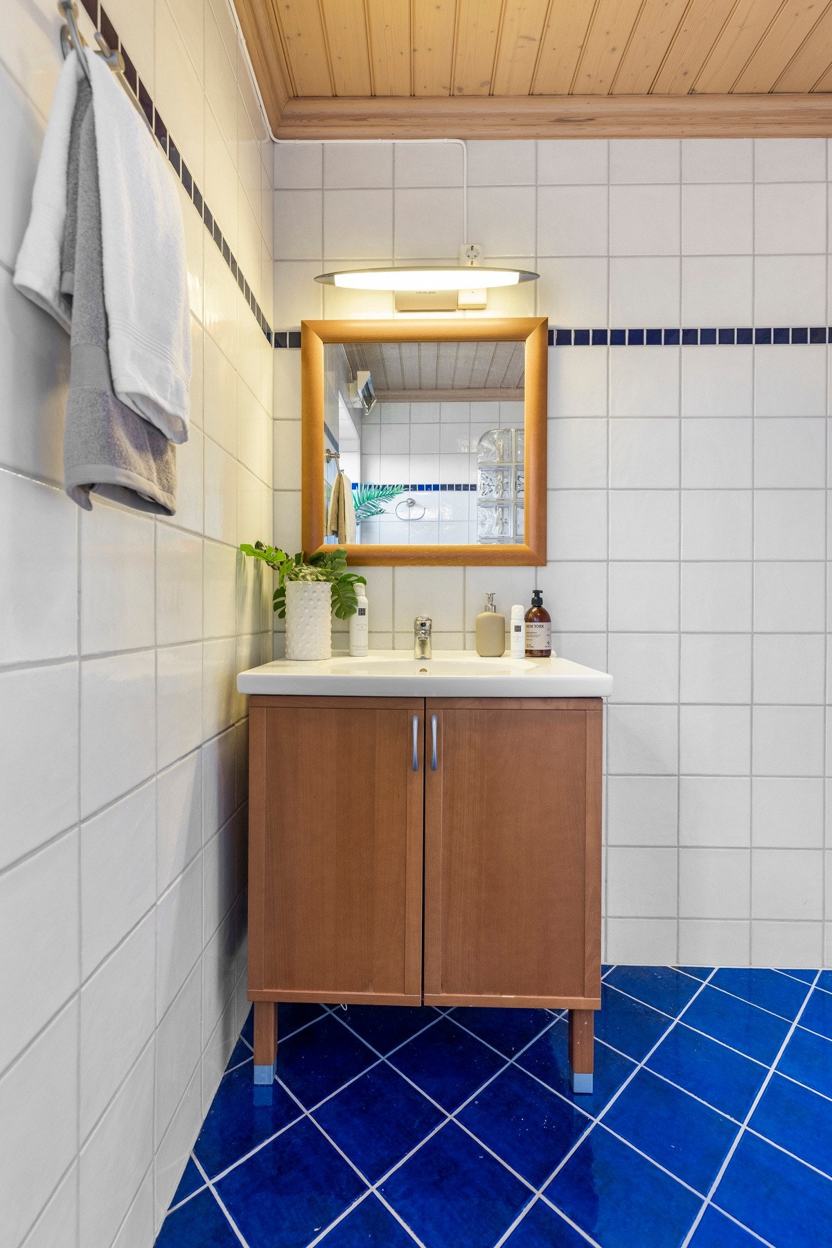 Rommet er utstyrt med innredning med profilerte fronter og nedfelt servant, speil med lys og skap over servant Galleribilde