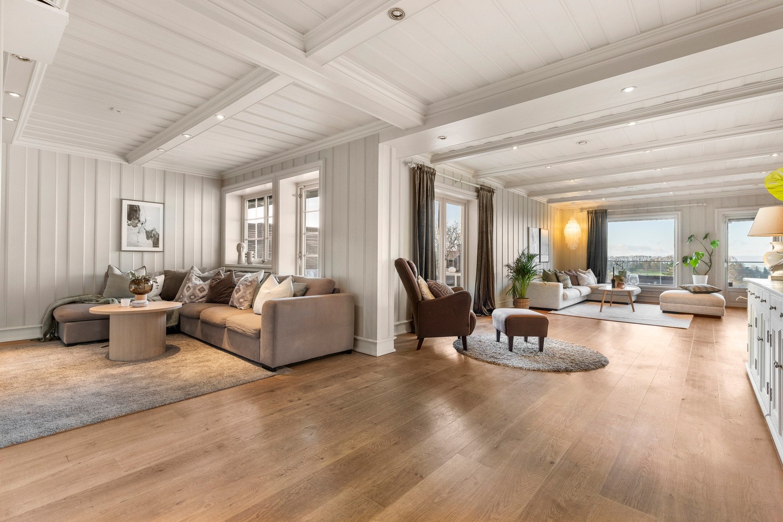 Stuen er romslig og byr på gode muligheter for ulike møbleringsløsninger, enten du ønsker en sosial sone med sofa og lenestoler eller plass til spisebord Galleribilde