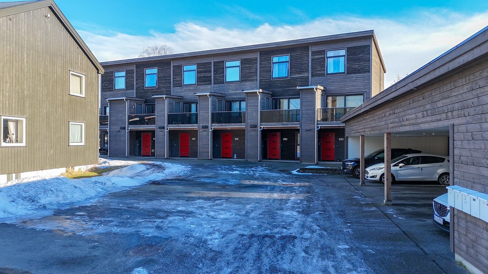 Asfaltert innkjørsel. Carport med bod medfølger, men det er også ekstra parkering for beboere og gjester på felles biloppstillingsplasser(på venstre hånd) Galleribilde