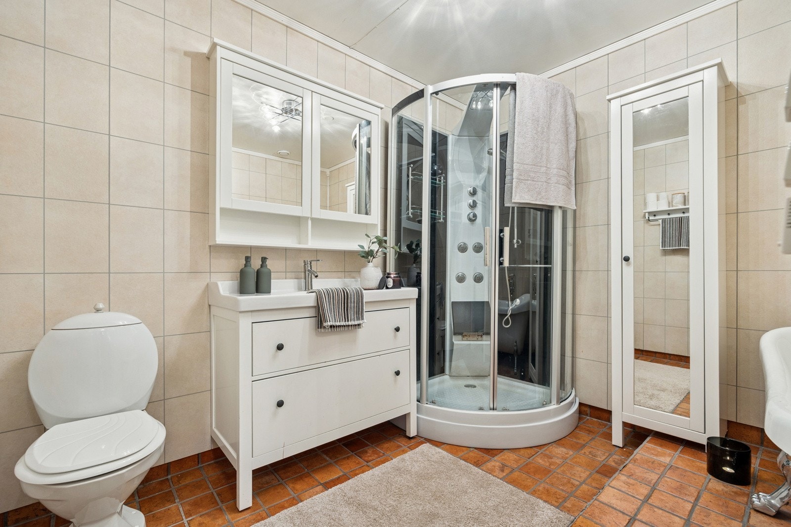 Badet har gulvvarme og er utstyrt med klosett, romslig dusjkabinett, servant og gode skap/oppbevaringsløsninger. Galleribilde