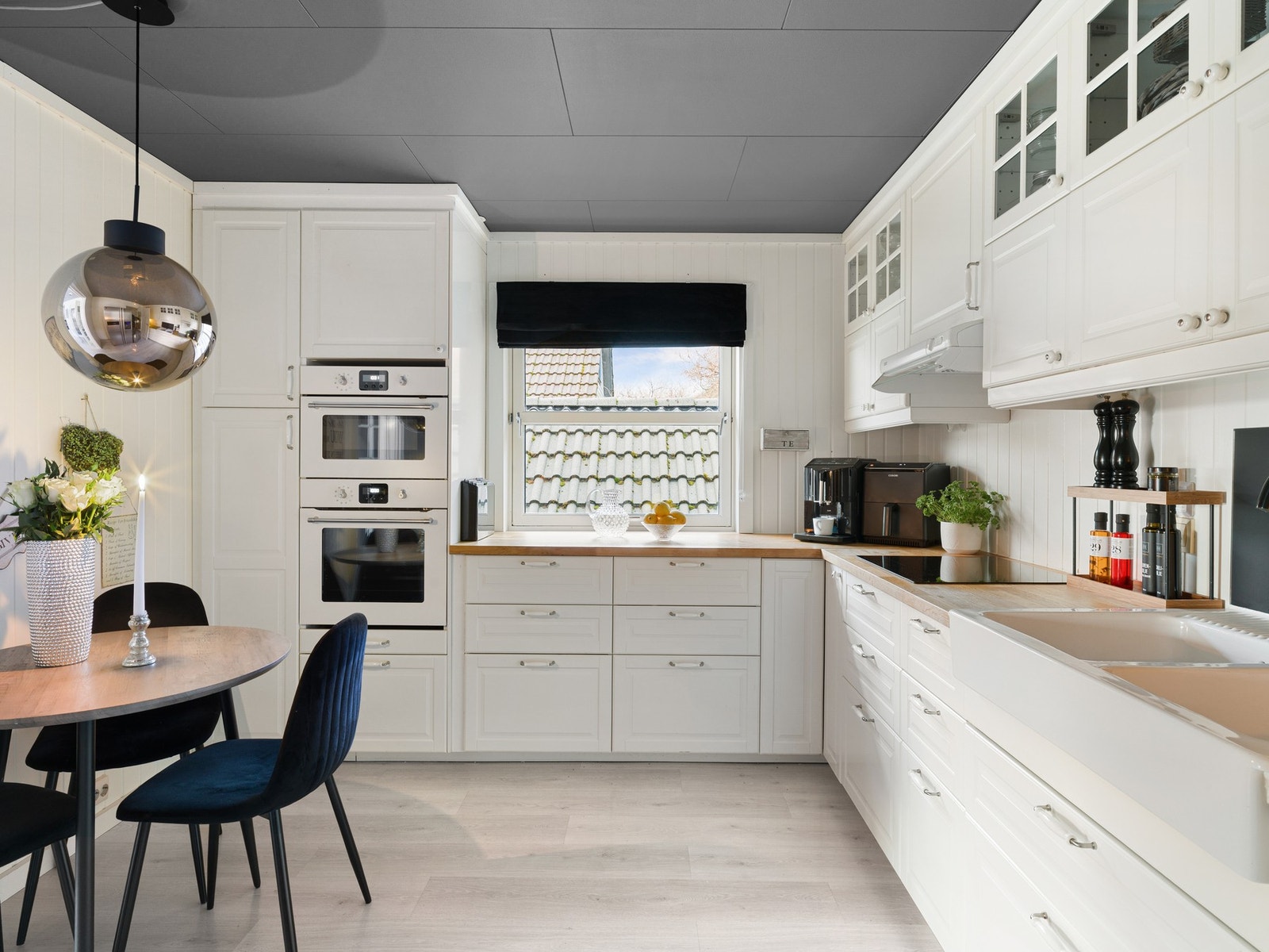 Kjøkkenet har en innredning bestående av hvite profilerte fronter og benkeplate i tre. Galleribilde